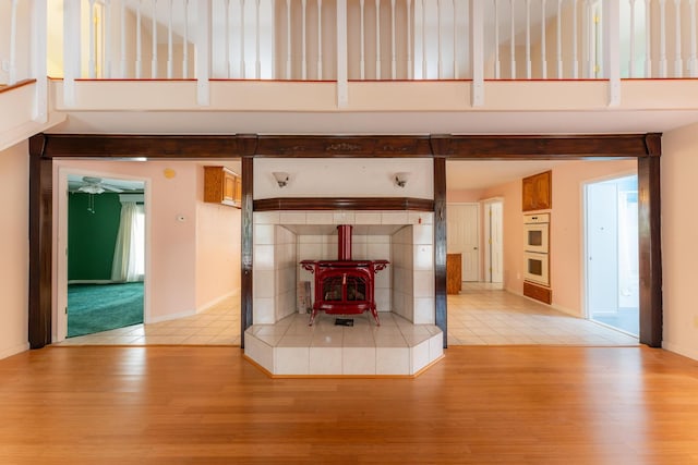 interior details featuring a wood stove, baseboards, wood finished floors, and white double oven