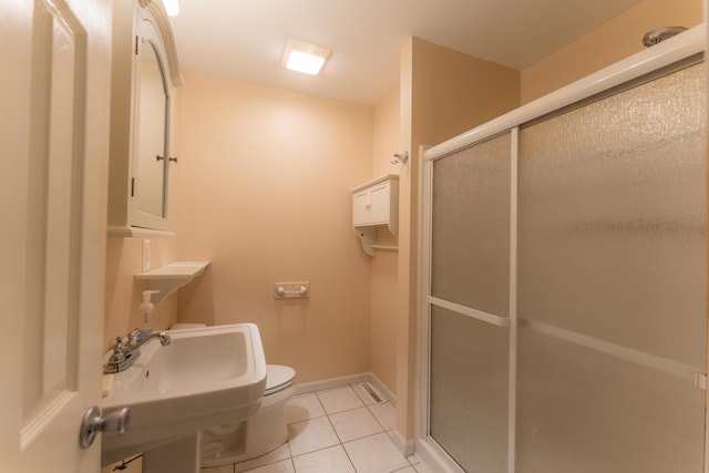 bathroom with a stall shower, tile patterned flooring, toilet, and baseboards