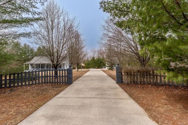 surrounding community featuring driveway and a fenced front yard