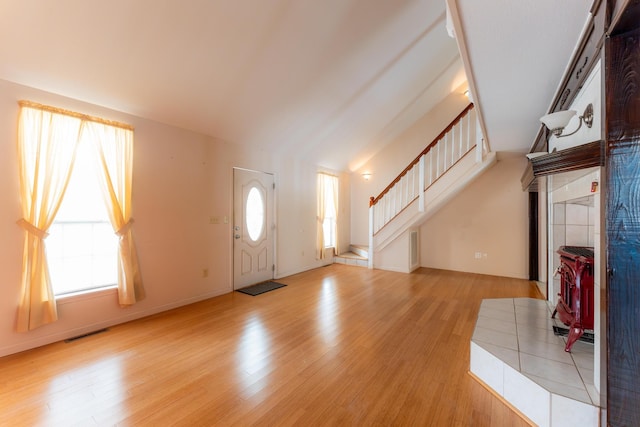 entryway with baseboards, visible vents, stairway, and light wood finished floors