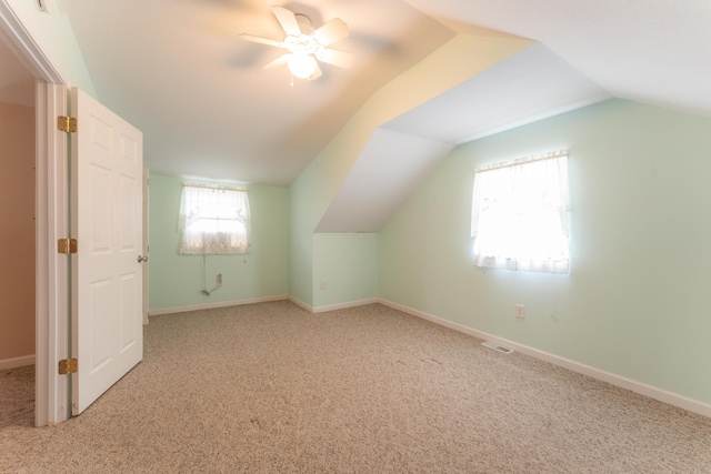 additional living space with carpet, visible vents, vaulted ceiling, and baseboards