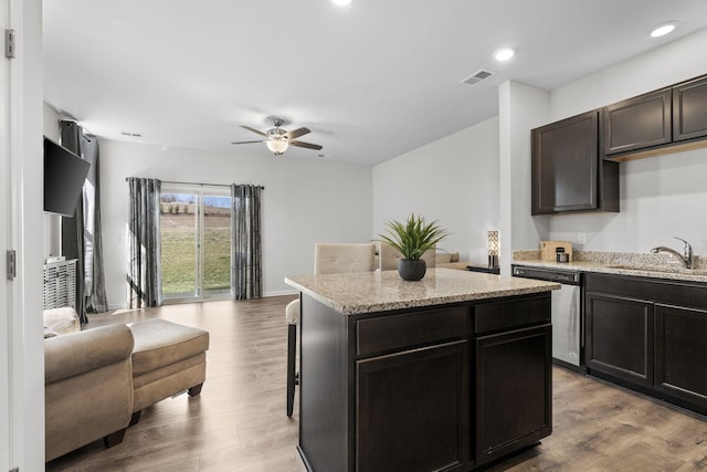 kitchen with visible vents, open floor plan, wood finished floors, stainless steel dishwasher, and a sink