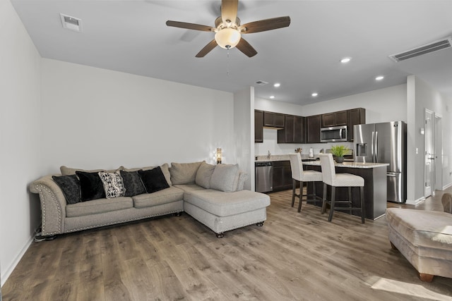 living area with baseboards, visible vents, a ceiling fan, wood finished floors, and recessed lighting