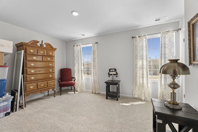 sitting room with carpet floors, visible vents, and baseboards