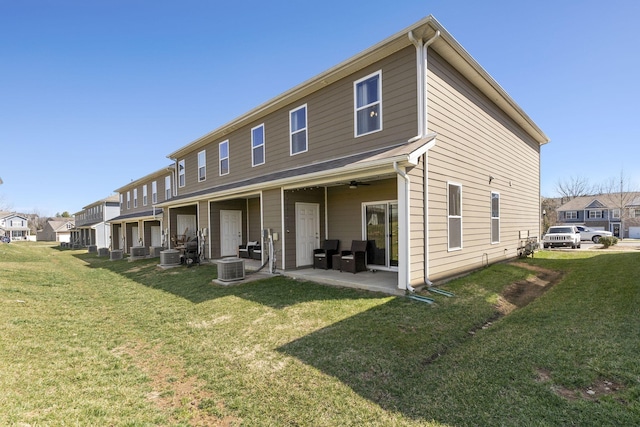 back of house featuring a patio, a lawn, a residential view, and a ceiling fan