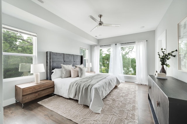 bedroom featuring baseboards, wood finished floors, and a ceiling fan