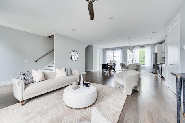 living area featuring stairway, wood finished floors, and baseboards