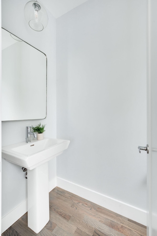 bathroom featuring a sink, baseboards, and wood finished floors