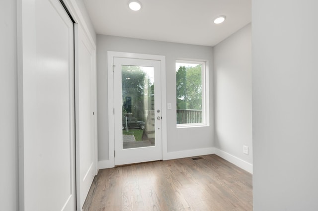 doorway to outside with recessed lighting, visible vents, baseboards, and wood finished floors