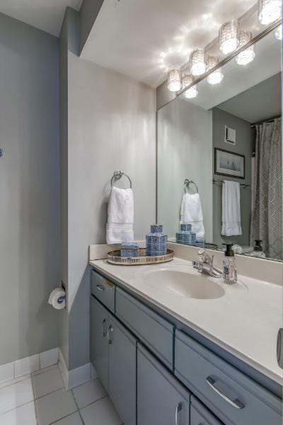 bathroom featuring tile patterned flooring, vanity, and baseboards