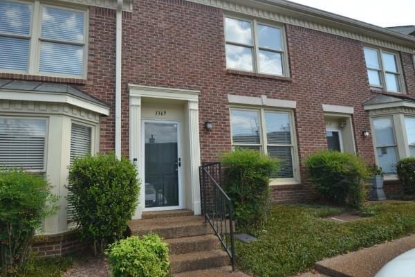 view of property featuring entry steps and brick siding