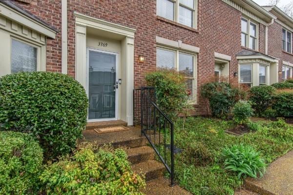 entrance to property featuring brick siding