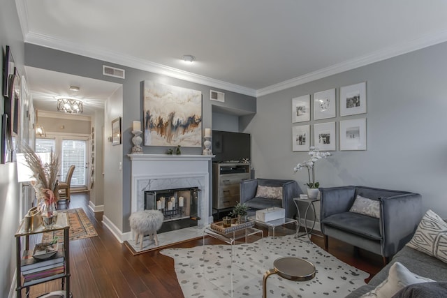 living area with visible vents, dark wood-type flooring, and ornamental molding