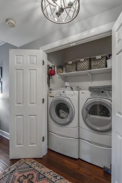 laundry area featuring dark wood-style floors, laundry area, a notable chandelier, and washer and clothes dryer