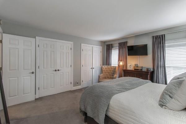 carpeted bedroom featuring multiple closets