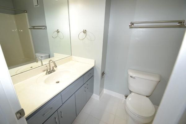 bathroom featuring walk in shower, vanity, toilet, and baseboards