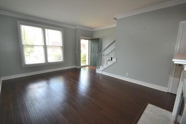 unfurnished living room with ornamental molding, stairway, wood finished floors, and baseboards