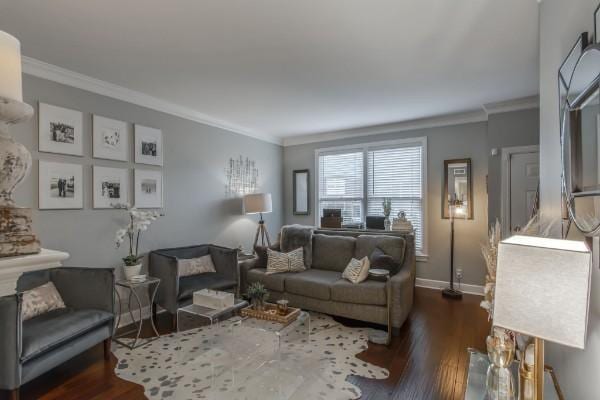 living area with dark wood-style flooring, crown molding, and baseboards