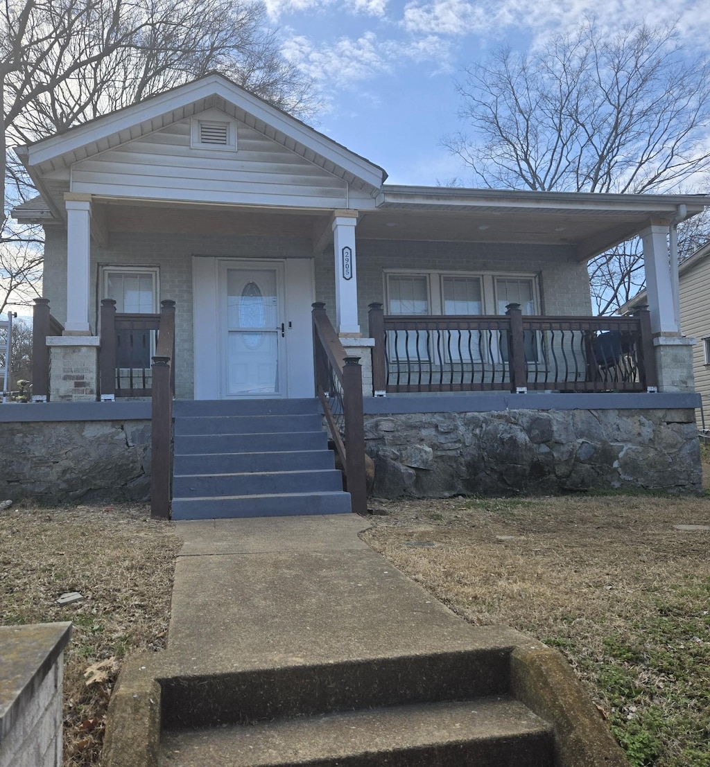 view of front of house featuring a porch and brick siding