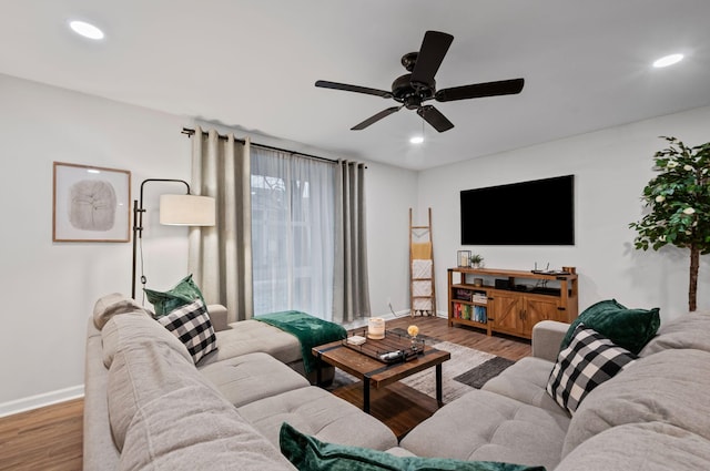 living room featuring baseboards, wood finished floors, and recessed lighting