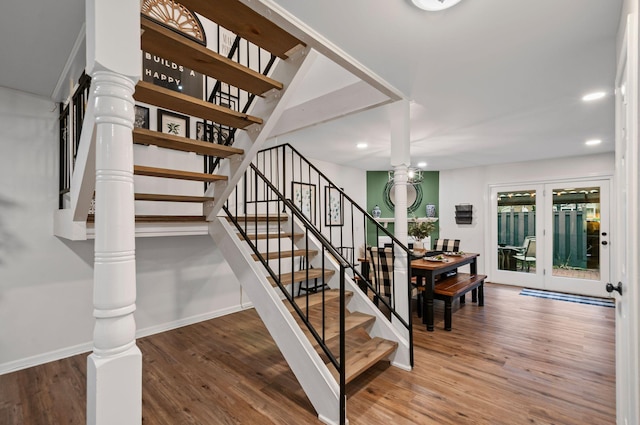 staircase with ornate columns, baseboards, wood finished floors, and recessed lighting