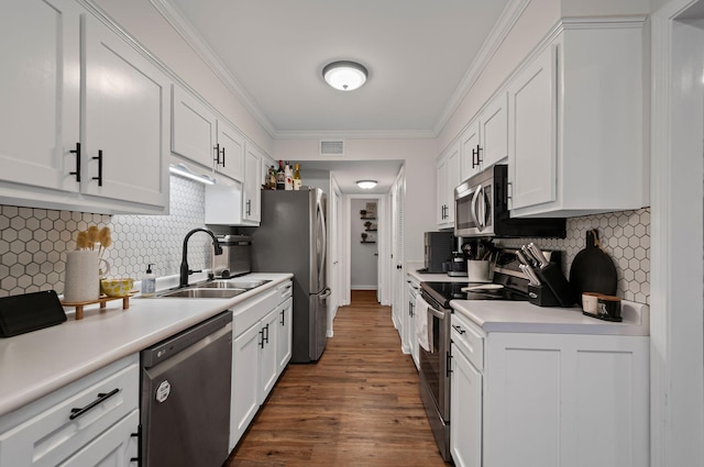 kitchen with stainless steel appliances, ornamental molding, a sink, and white cabinetry