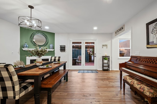 dining room featuring french doors, a notable chandelier, recessed lighting, wood finished floors, and baseboards