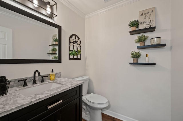 bathroom with baseboards, toilet, wood finished floors, crown molding, and vanity