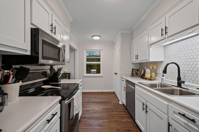 kitchen with light countertops, appliances with stainless steel finishes, ornamental molding, white cabinets, and a sink