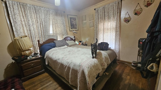 bedroom with ornamental molding and wood finished floors