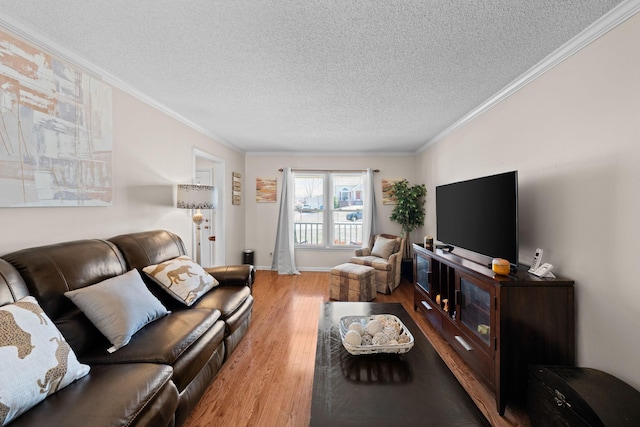 living area featuring a textured ceiling, ornamental molding, wood finished floors, and baseboards