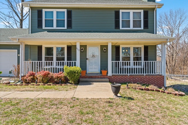 traditional style home featuring covered porch, a shingled roof, and a garage