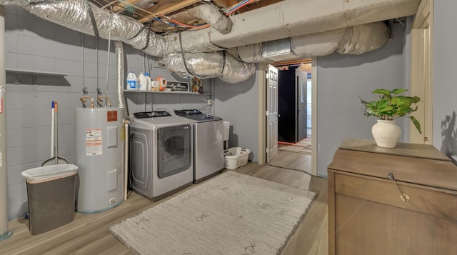 laundry room with light wood-style floors, water heater, laundry area, and washer and clothes dryer