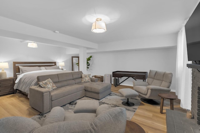 bedroom featuring light wood-style floors and a fireplace