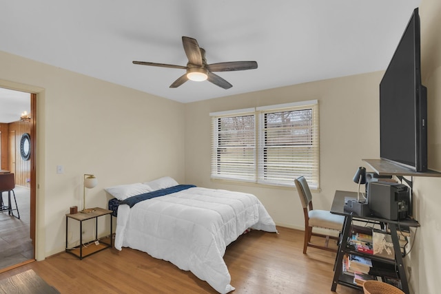 bedroom featuring light wood-type flooring, baseboards, and a ceiling fan