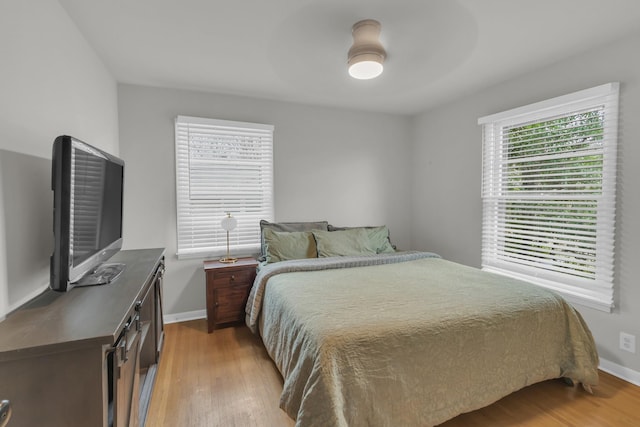 bedroom with light wood finished floors and baseboards