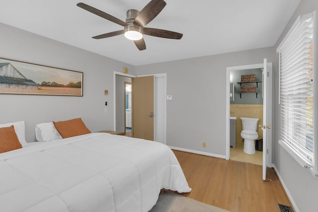 bedroom with baseboards, visible vents, a ceiling fan, connected bathroom, and wood finished floors