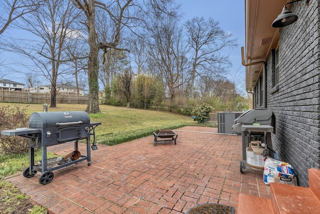 view of patio with central AC, an outdoor fire pit, grilling area, and a fenced backyard