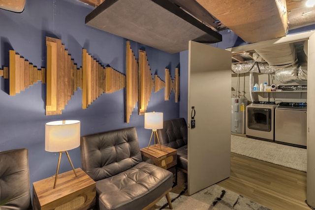 sitting room featuring water heater, washer and dryer, and wood finished floors