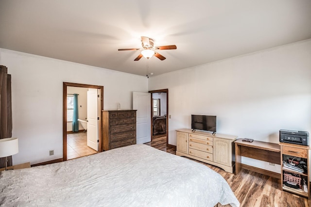 bedroom with multiple windows, baseboards, and wood finished floors