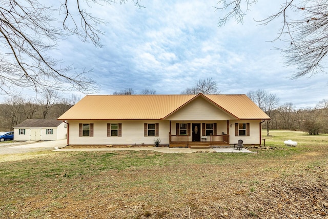 view of front of property featuring a front yard, covered porch, and metal roof