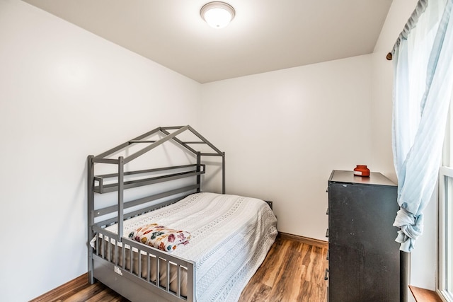 bedroom featuring baseboards and wood finished floors