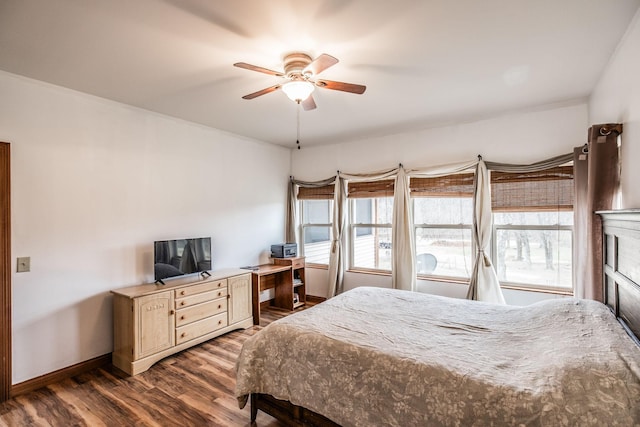 bedroom with a ceiling fan, dark wood finished floors, and baseboards