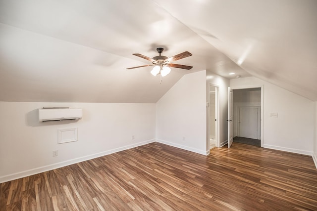 additional living space with ceiling fan, a wall mounted air conditioner, wood finished floors, and baseboards