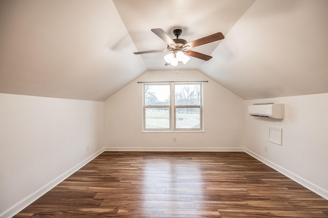 bonus room featuring dark wood-style flooring, a wall mounted air conditioner, vaulted ceiling, and baseboards