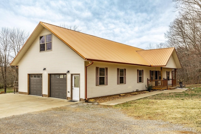 view of front of home featuring a garage, driveway, and metal roof