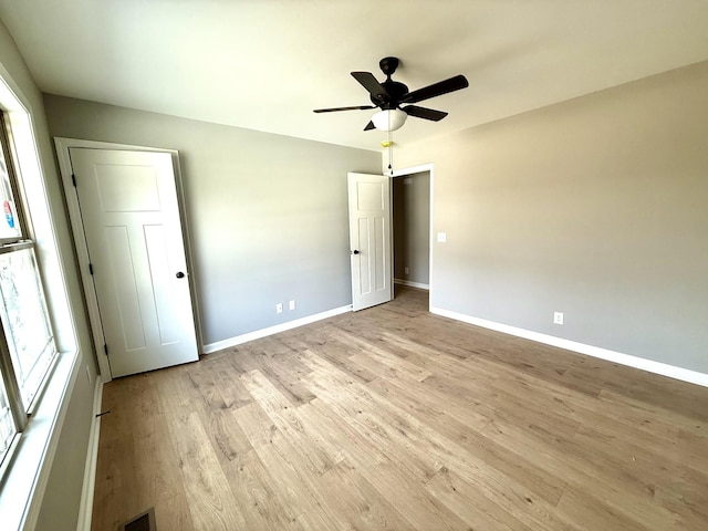 unfurnished bedroom featuring light wood-style floors, visible vents, baseboards, and a ceiling fan