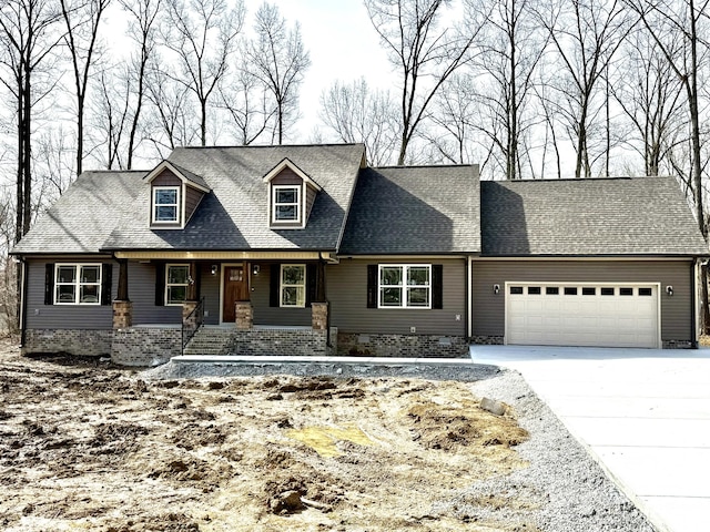 cape cod home featuring a garage, driveway, and a shingled roof