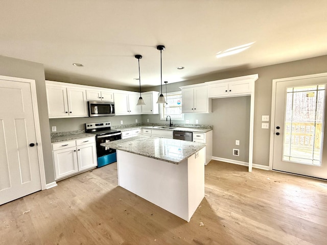 kitchen featuring stainless steel appliances, light wood-type flooring, a sink, and white cabinetry