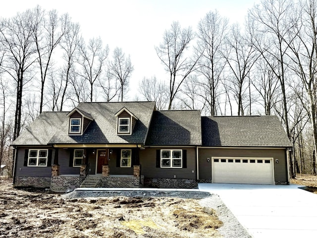 cape cod home with concrete driveway, roof with shingles, and an attached garage